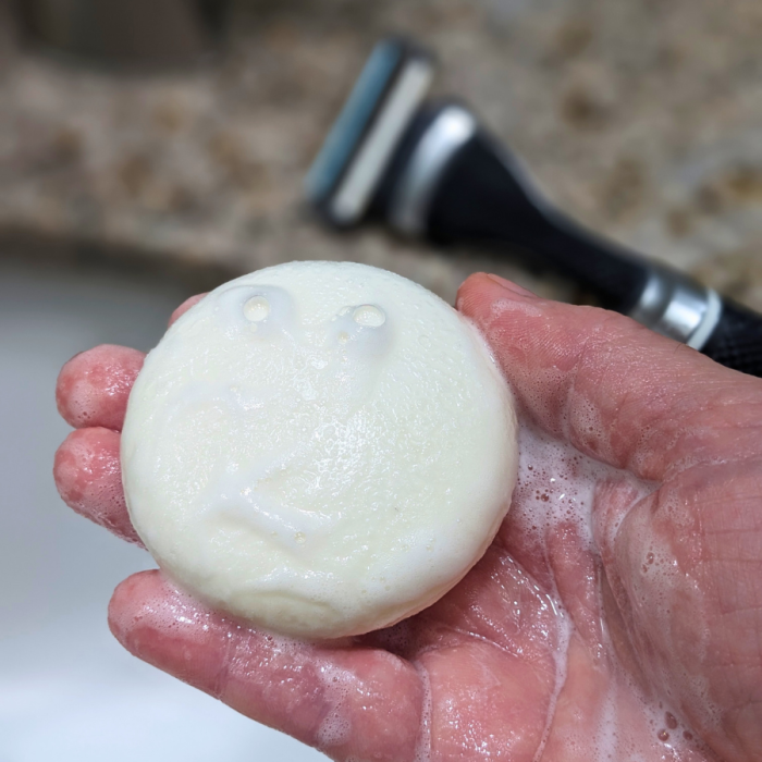 Tangie Unscented Shave Cream Bar lathering in hand with bubbles, showing its creamy, foamy texture for a smooth, zero-waste shave