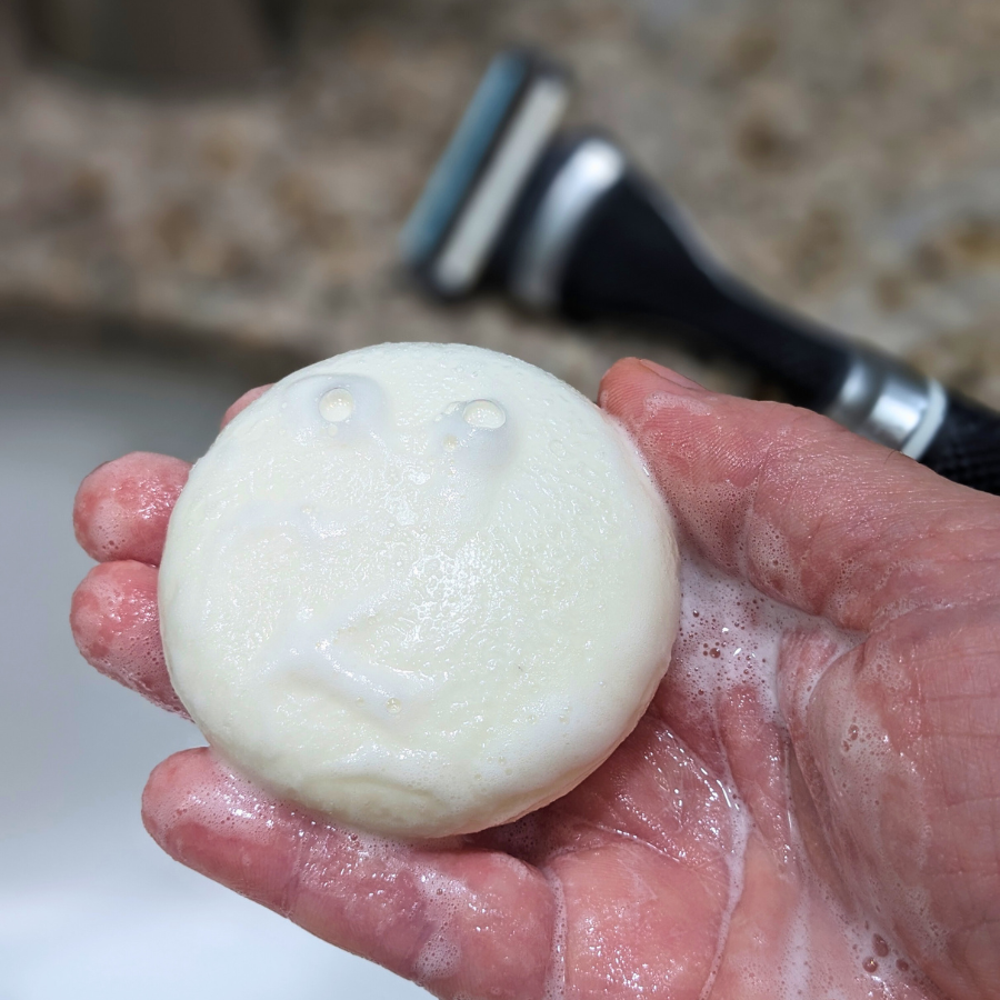 Tangie Unscented Shave Cream Bar lathering in hand with bubbles, showing its creamy, foamy texture for a smooth, zero-waste shave